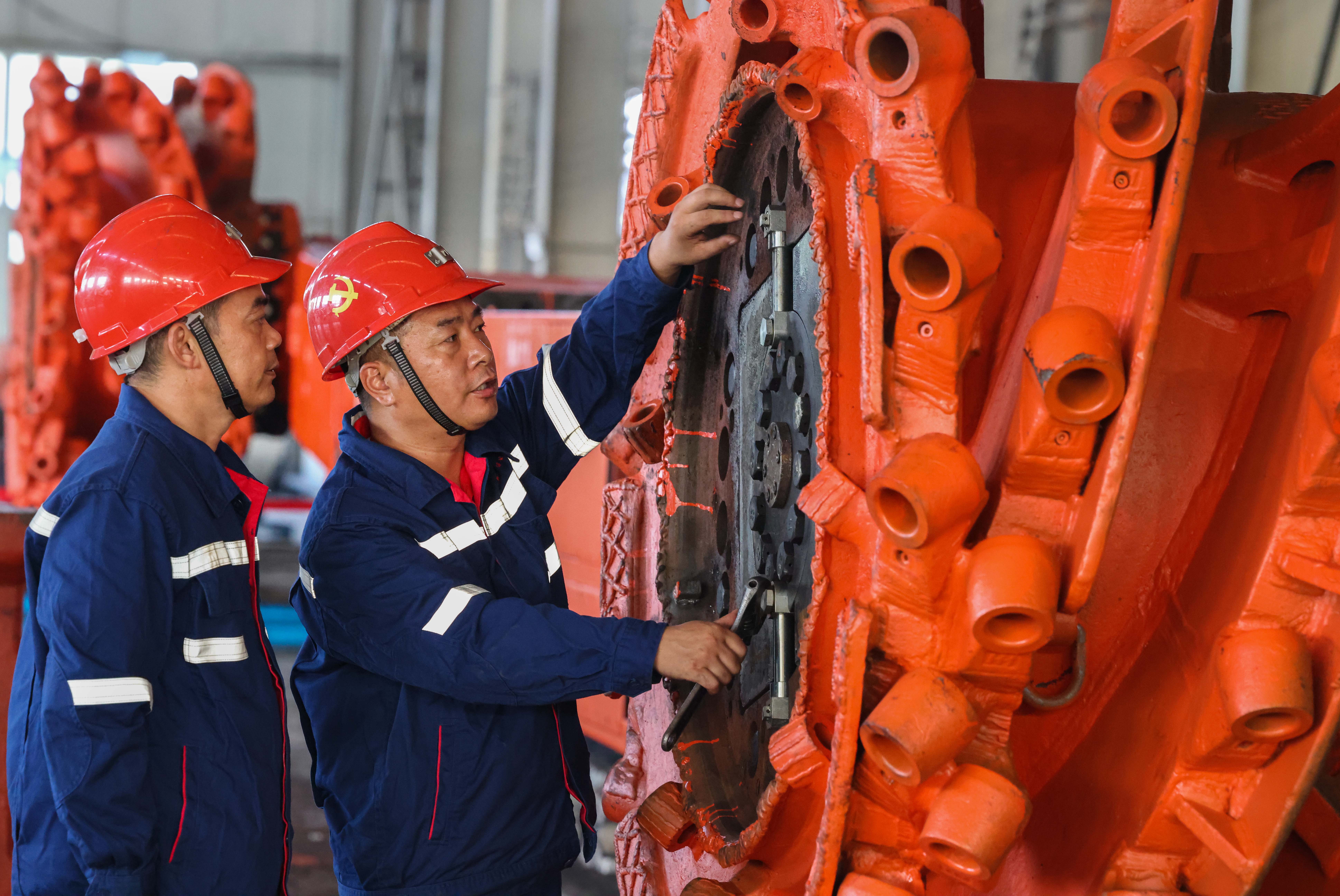 淮北礦業(yè)集團“工匠大師工作室”核心成員王忠才和徒弟共同探討綜采機維修技巧。鄭洪光攝